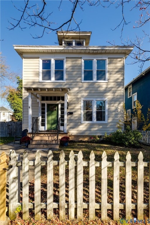 View of front of home with a fenced front yard and a patio