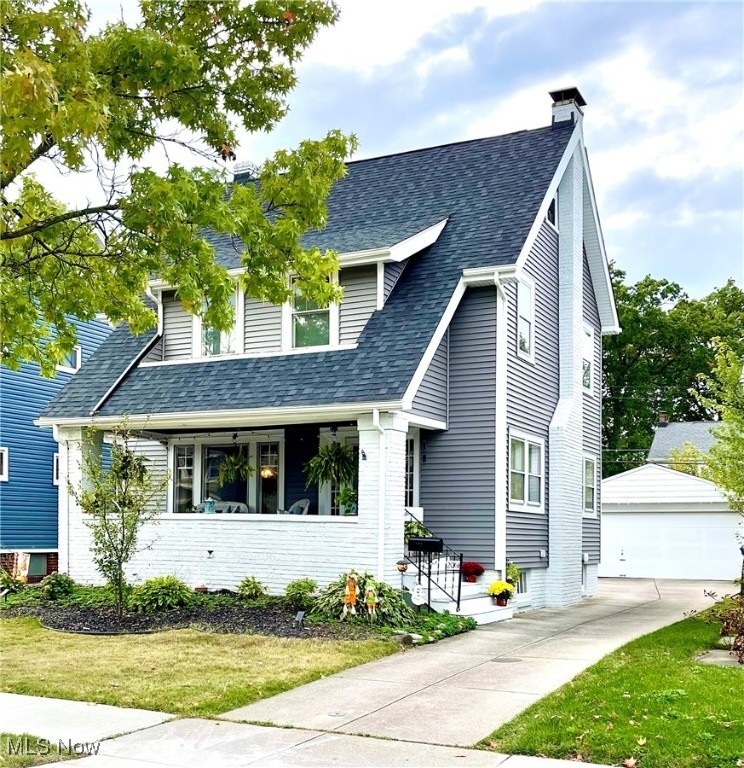 View of front of house featuring a newly  landscaped front yard, quaint covered front porch, new roof and siding and two car garage