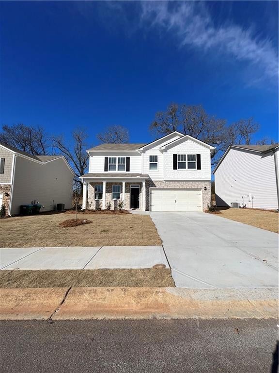 View of front of home featuring driveway, stone si
