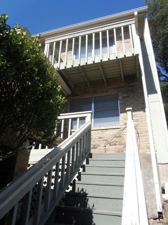 Back of property with brick siding and stairs