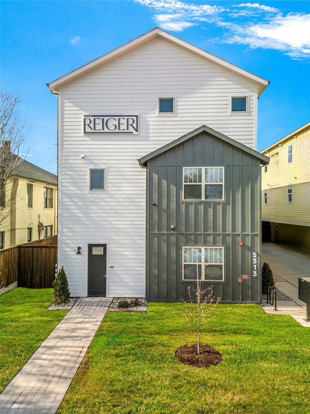 View of front of house with fence, a front lawn, a