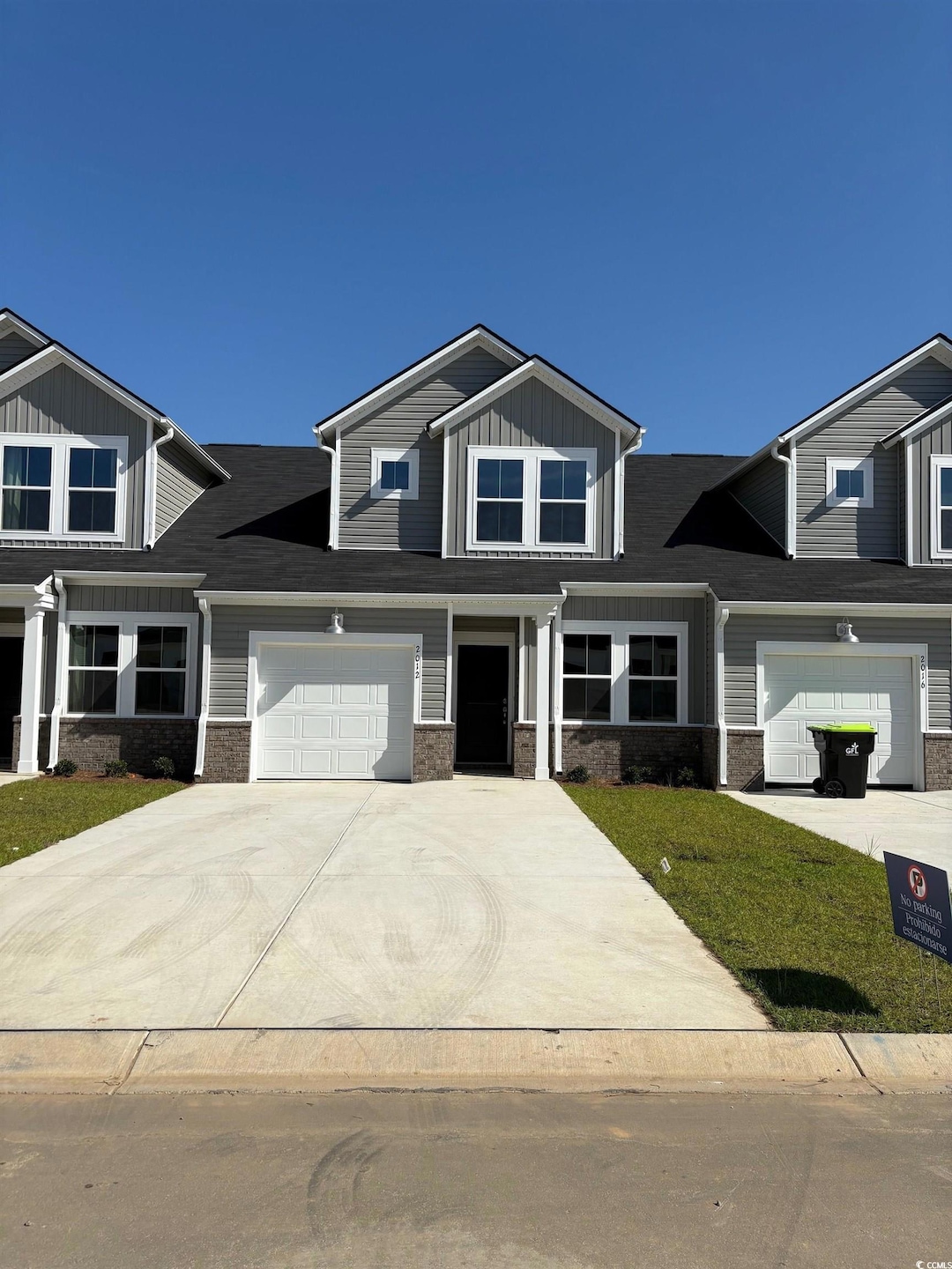 View of front of property featuring driveway, board and batten siding, an attached garage, and a front yard