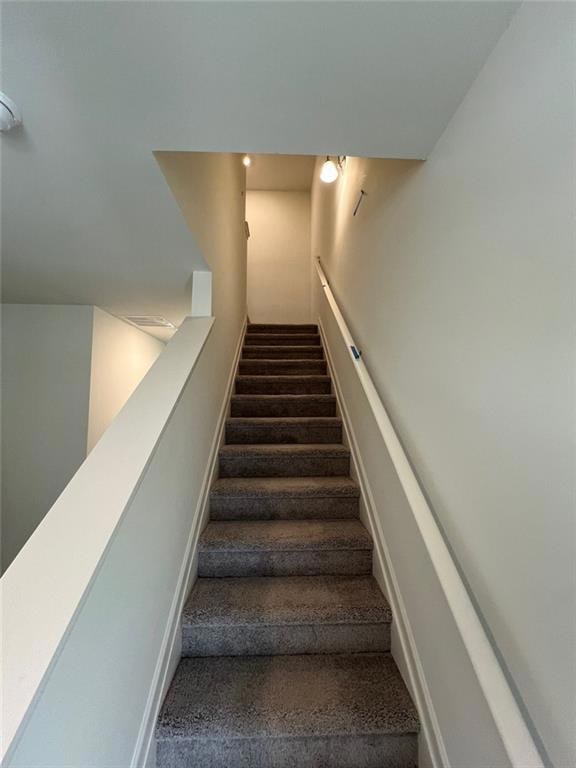 Stairway with carpet floors and baseboards
