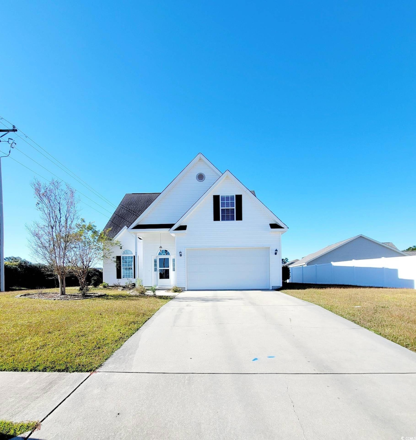 Traditional-style house featuring driveway, a front lawn, and an attached garage