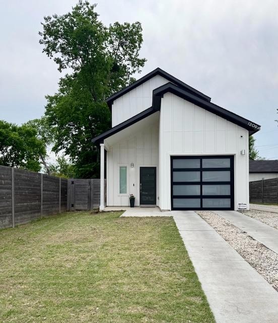 View of outdoor structure with a garage, fence, a