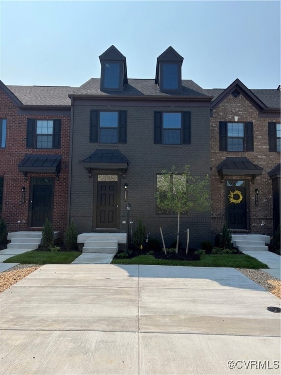Townhome / multi-family property featuring brick siding