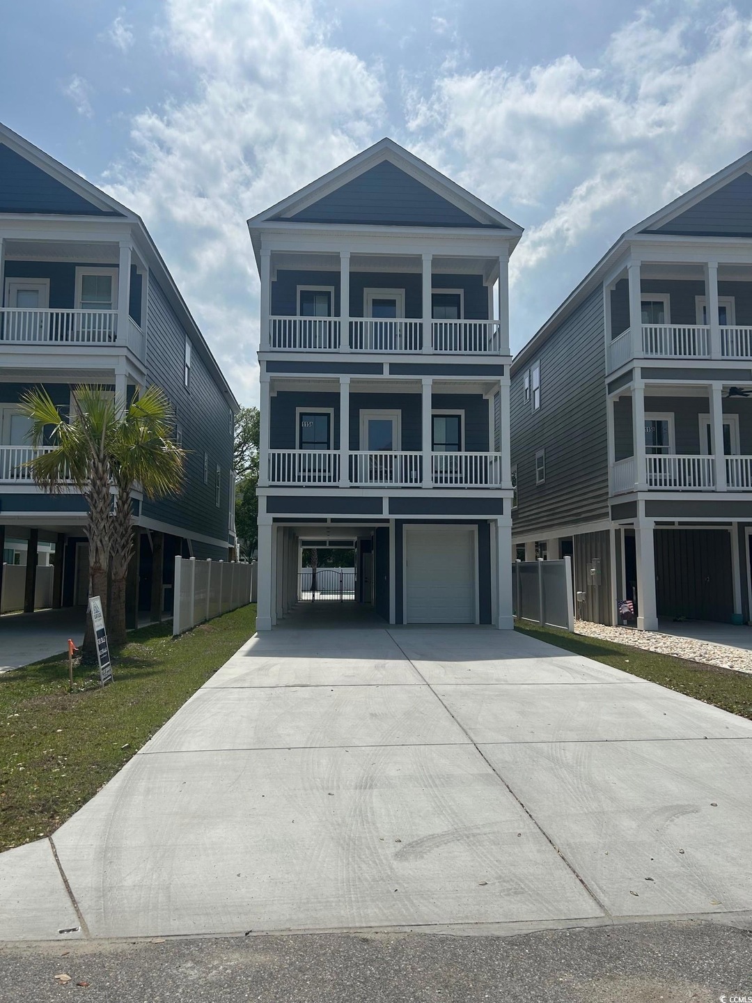 Raised beach house with an attached garage, drivew