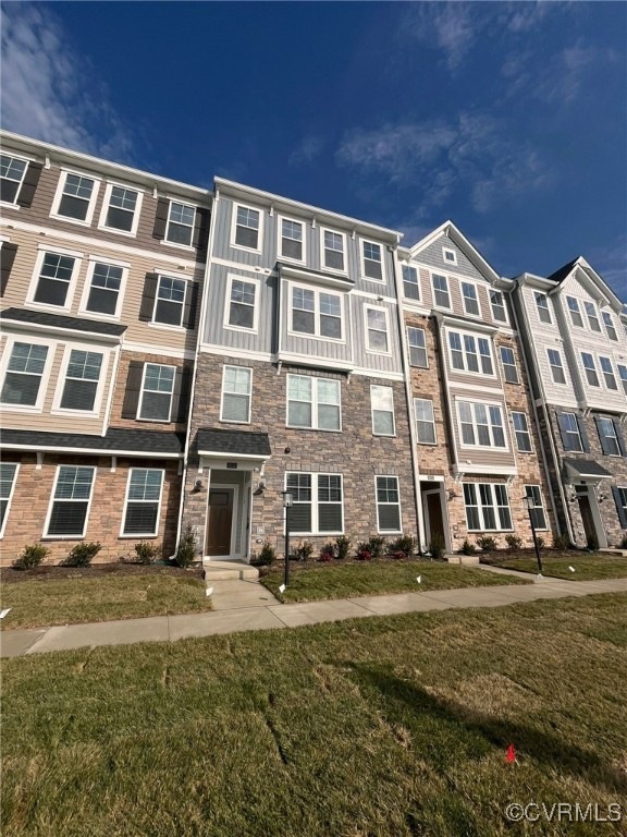View of property featuring a front lawn