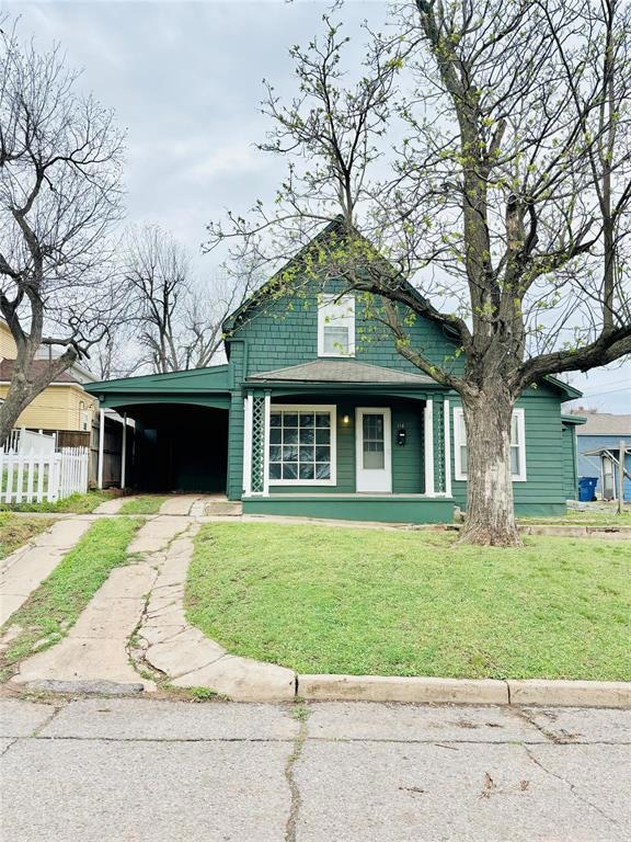 View of front of house featuring an attached carport, a porch, and driveway
