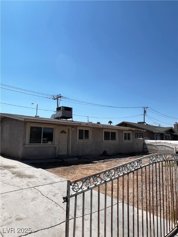 Ranch-style house with a fenced front yard and stucco siding