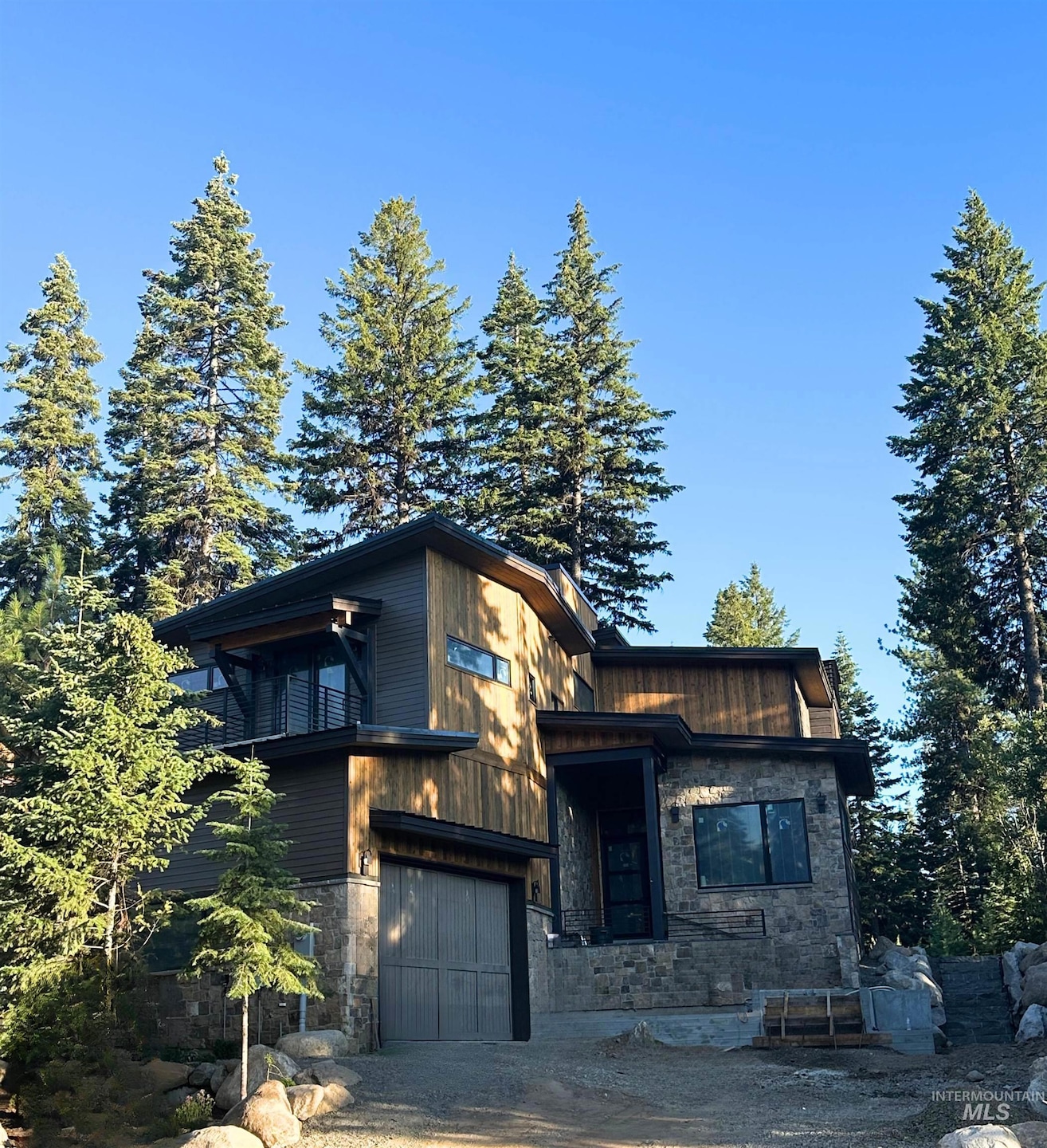 Contemporary home with stone siding and an attached garage
