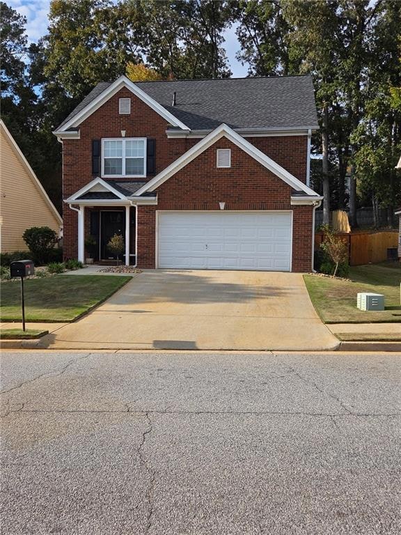 Traditional home with concrete driveway, brick siding, a front yard, and a garage