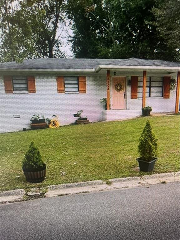 Ranch-style home with covered porch, a front lawn, and brick siding