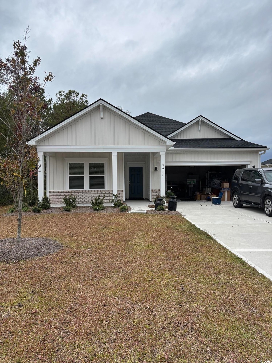 View of front facade featuring a garage, covered p