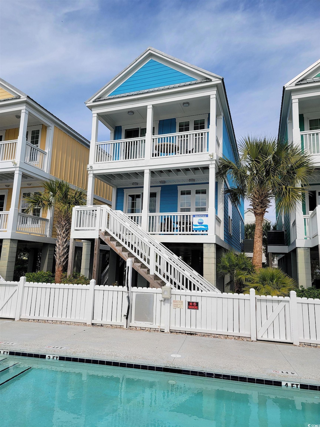 Rear view of property featuring a community pool a
