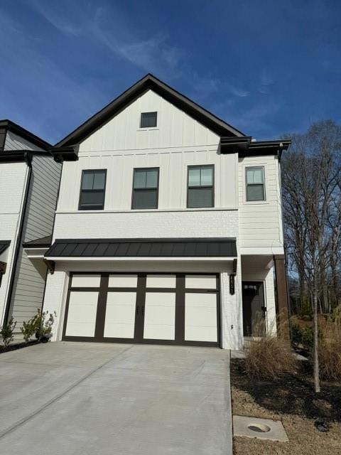 View of front facade with concrete driveway, board