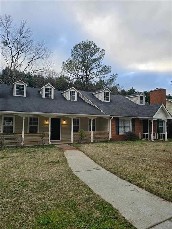 Cape cod home featuring covered porch and a front 