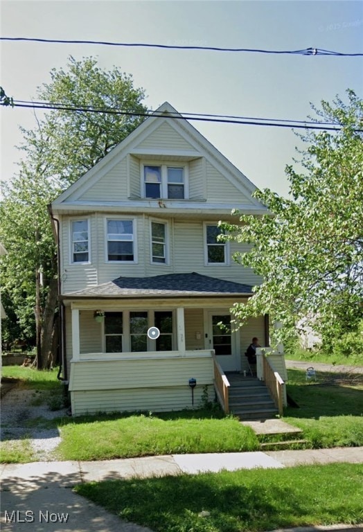 Traditional style home with covered porch and a front yard