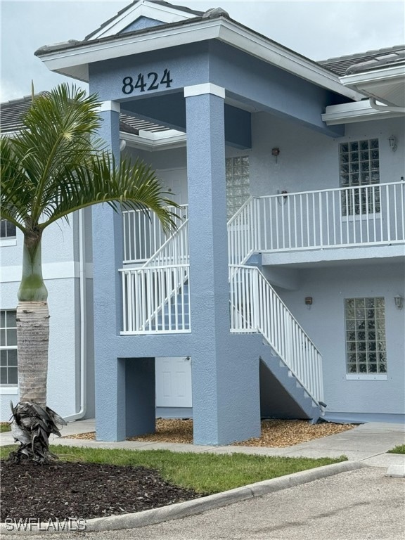 View of property exterior with stairway and stucco