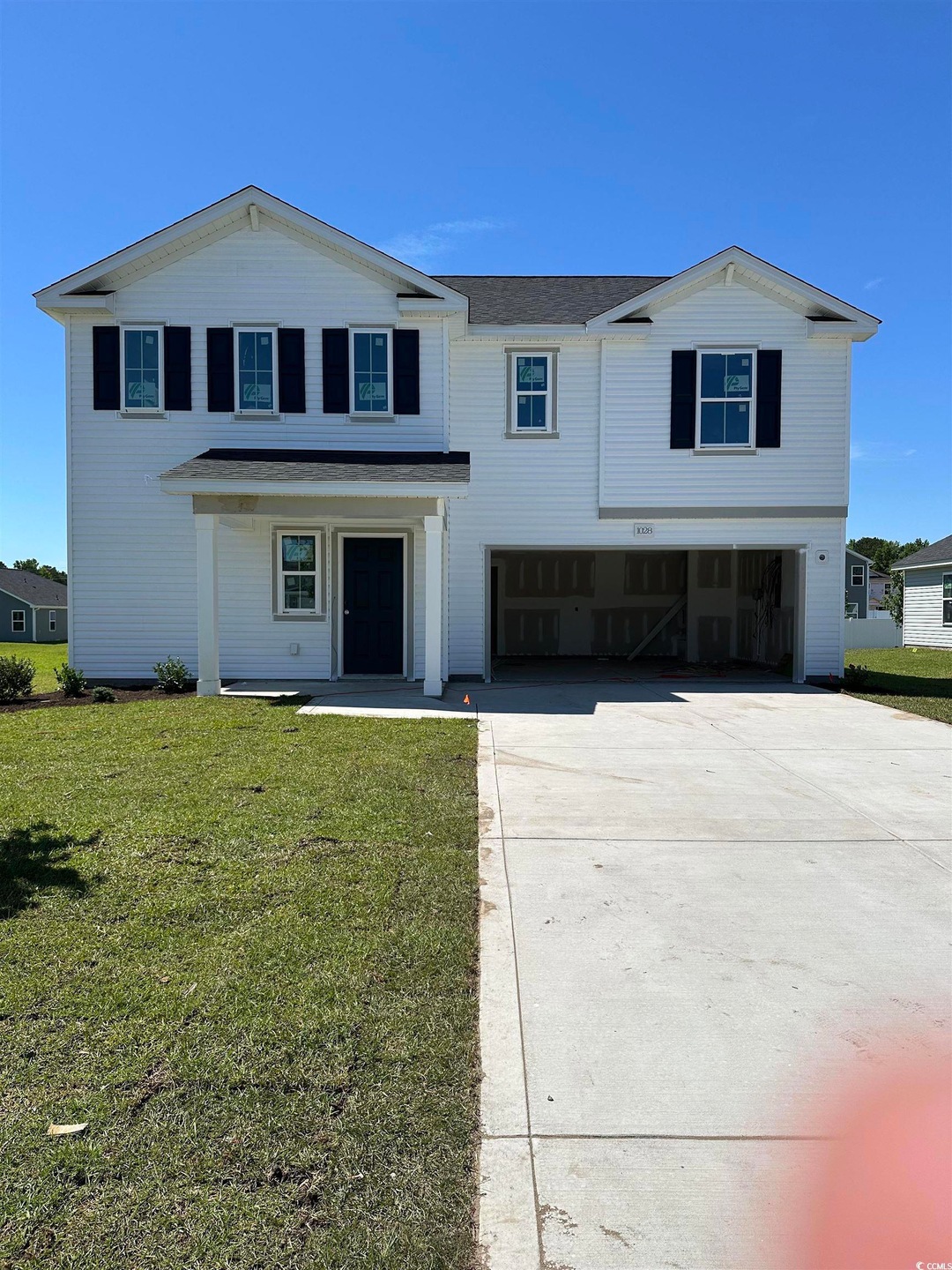 View of front of property with a garage, a front lawn, concrete driveway, and a porch