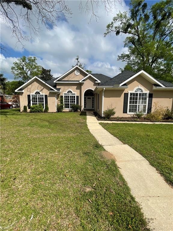 Ranch-style house featuring a front lawn, a shingl