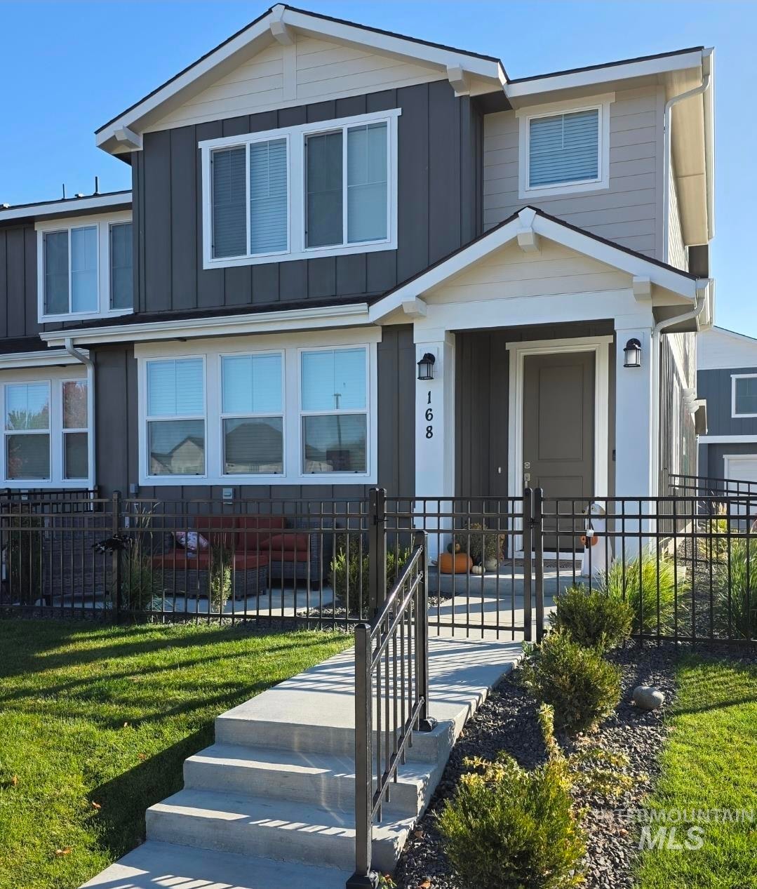 View of front facade with a fenced front yard and board and batten siding