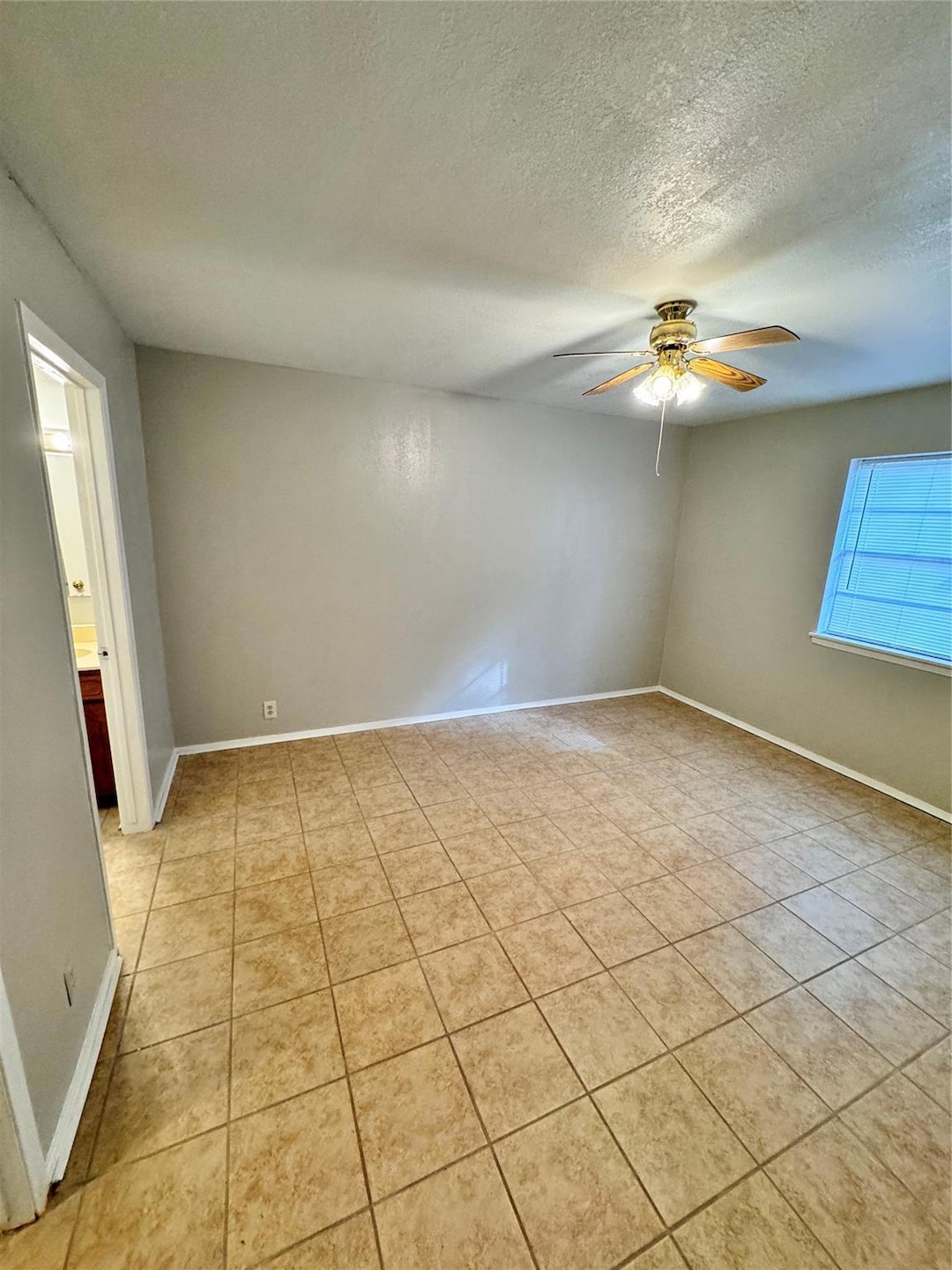 Empty room featuring a textured ceiling, ceiling f