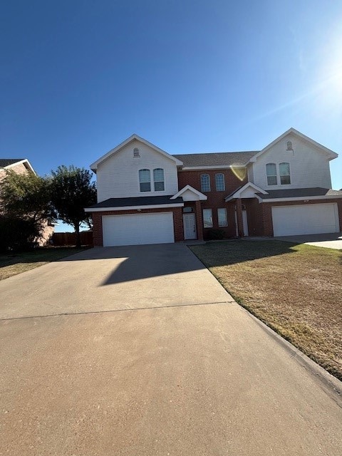 Traditional home with concrete driveway, an attached garage, and brick siding