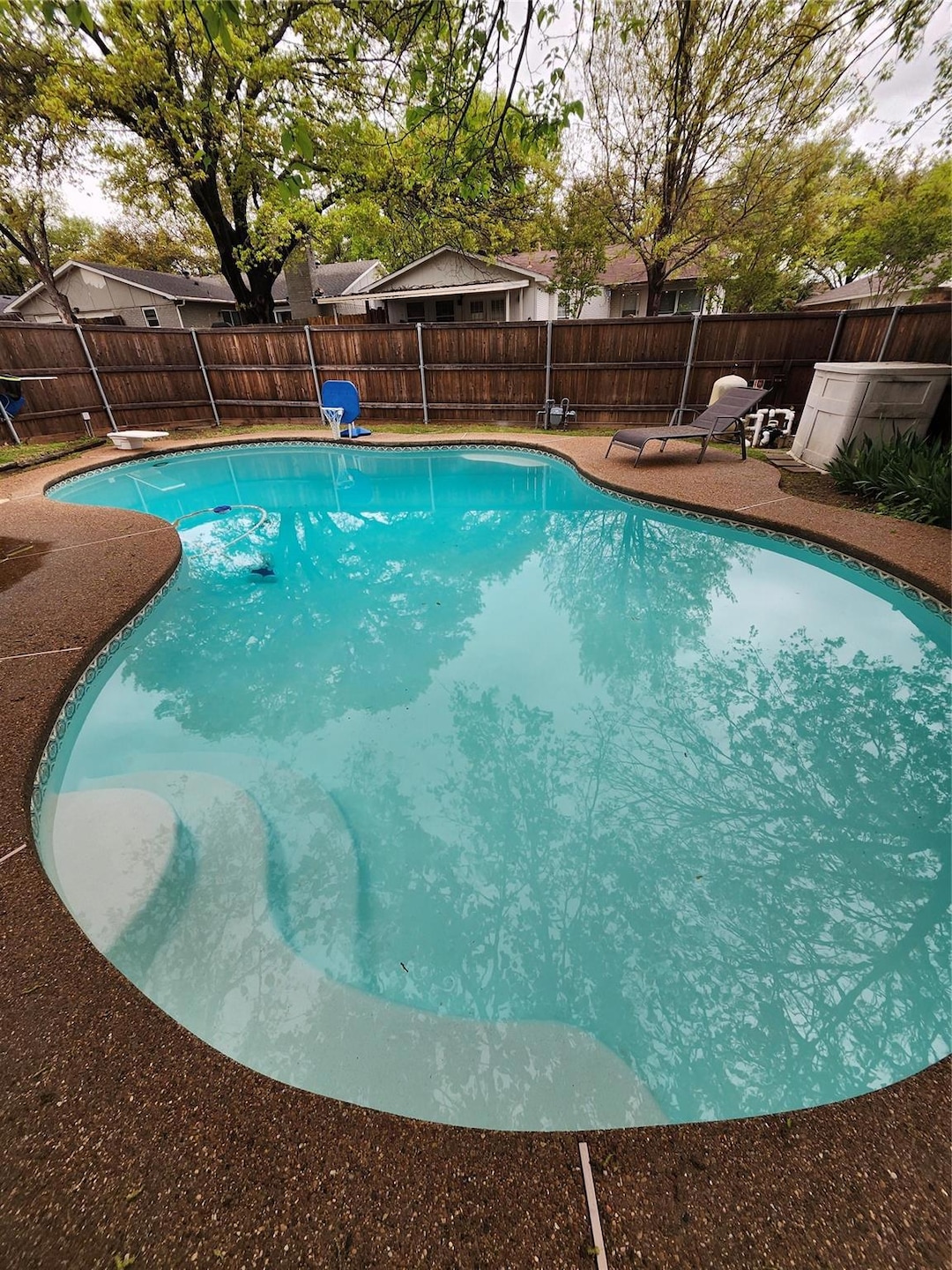 View of pool featuring a diving board, a fenced ba