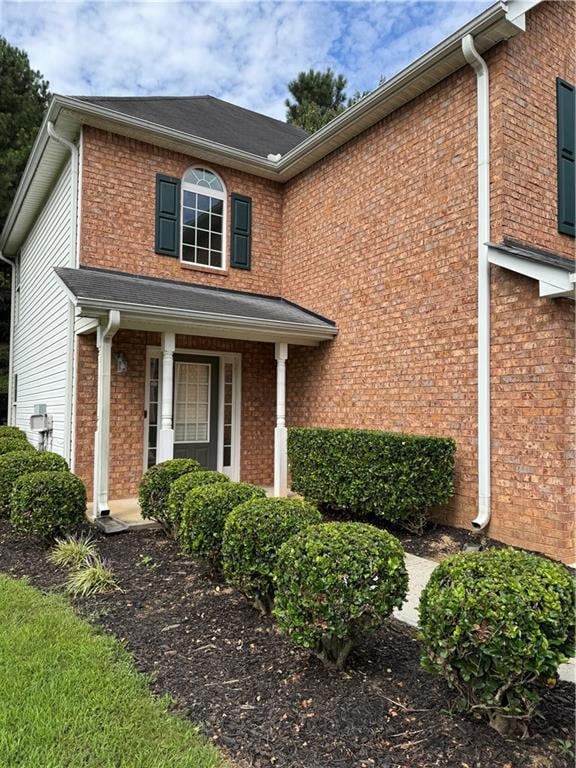 View of front facade with covered porch and brick siding