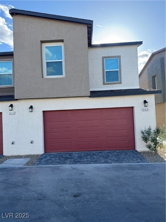 View of front facade with an attached garage, stuc