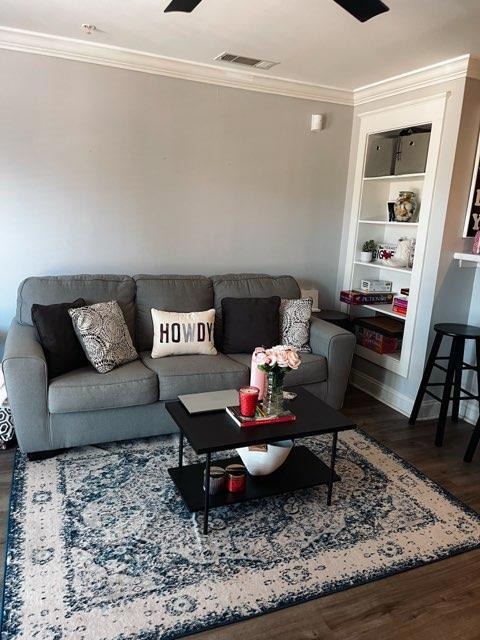 Living room featuring crown molding, wood finishe