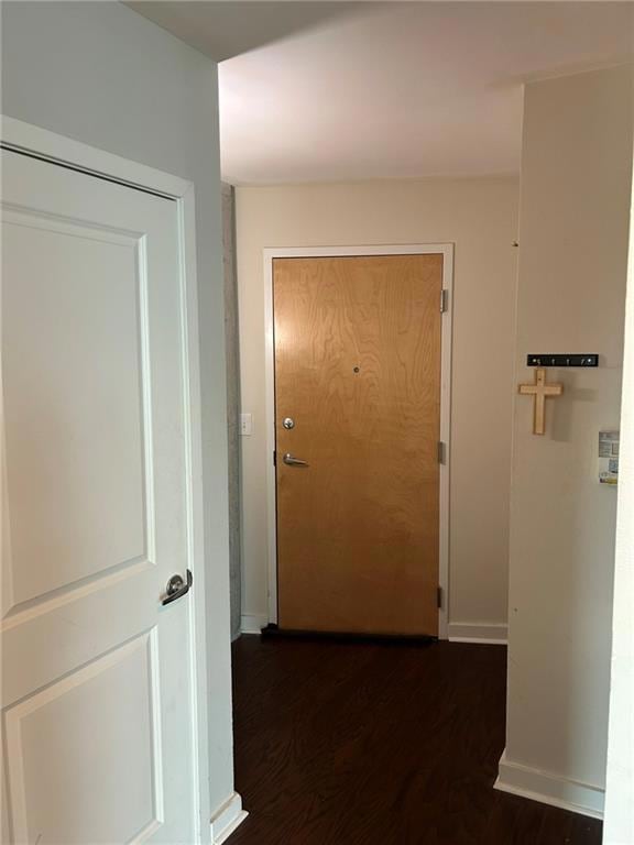 Corridor featuring wood finished floors and baseboards