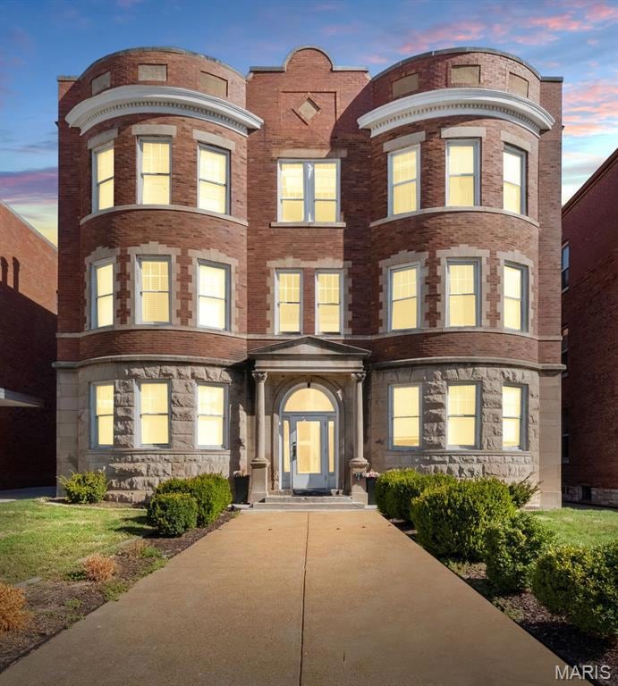 View of front facade featuring brick siding and stone siding