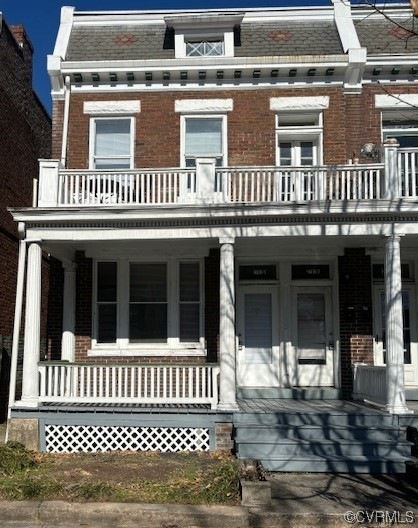 View of front of home with covered porch and a bal