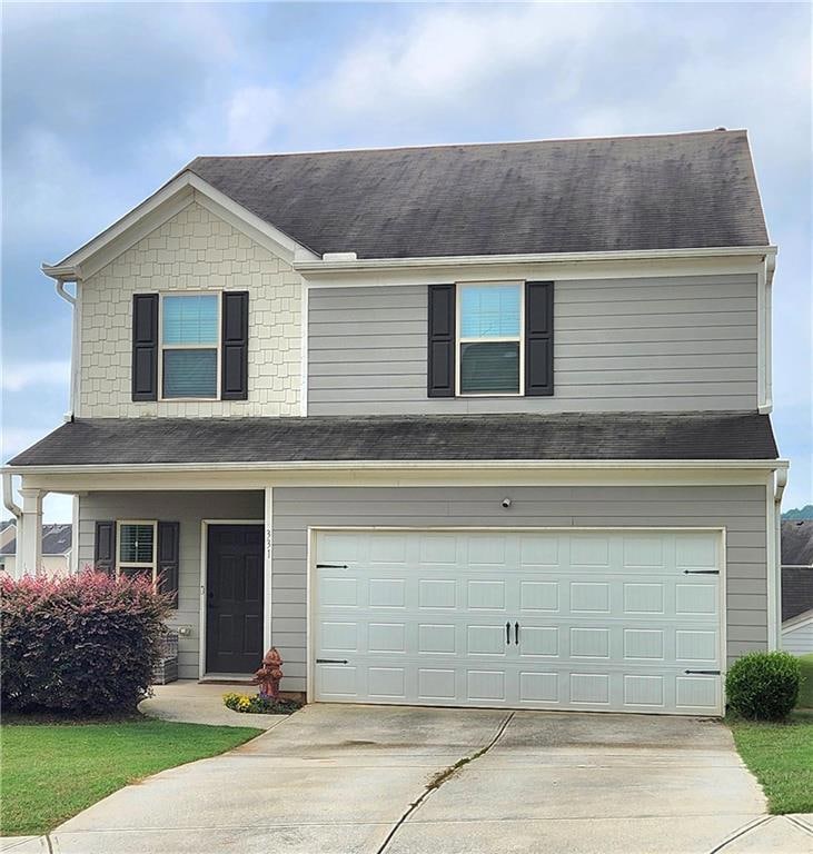 Traditional-style home with concrete driveway, a garage, and roof with shingles