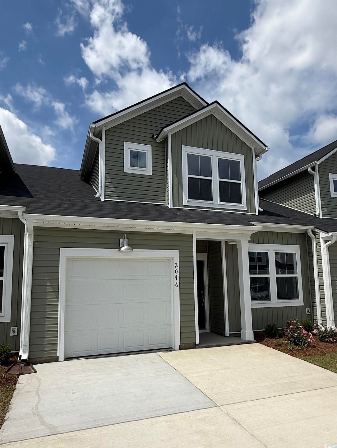 View of front of home featuring concrete driveway and board and batten siding