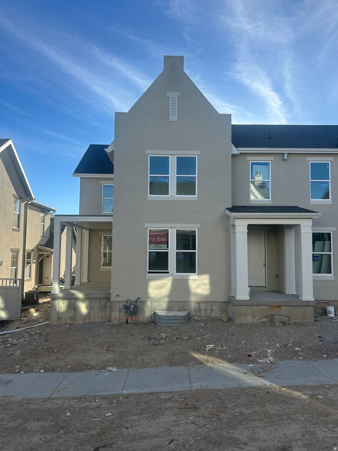 View of front of home with stucco siding, a shingled roof, and a porch