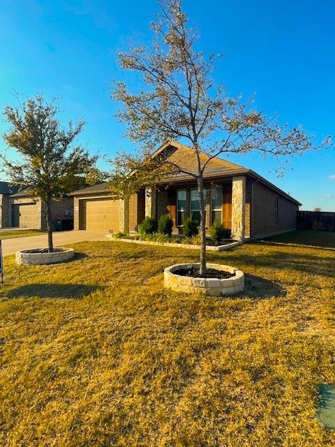 Single story home featuring brick siding, an attached garage, and concrete driveway