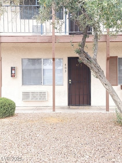 Entrance to property with a balcony and stucco sid