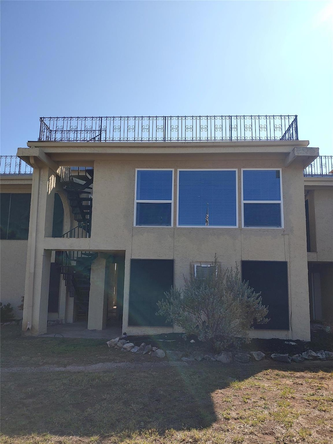 Back of house featuring stucco siding and stairs