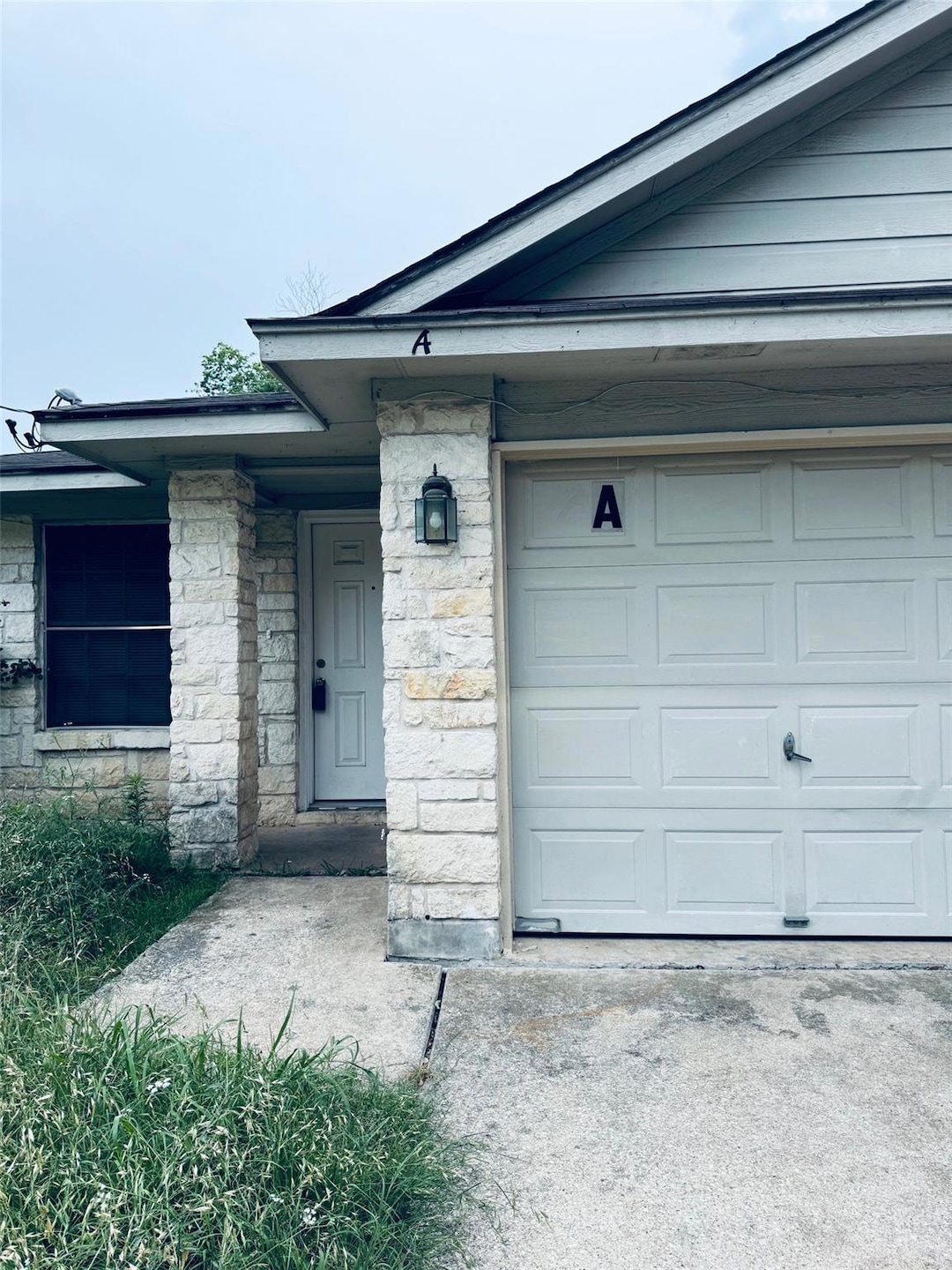 Property entrance with a garage, driveway, and st