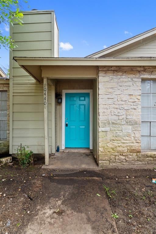Entrance to property with stone siding