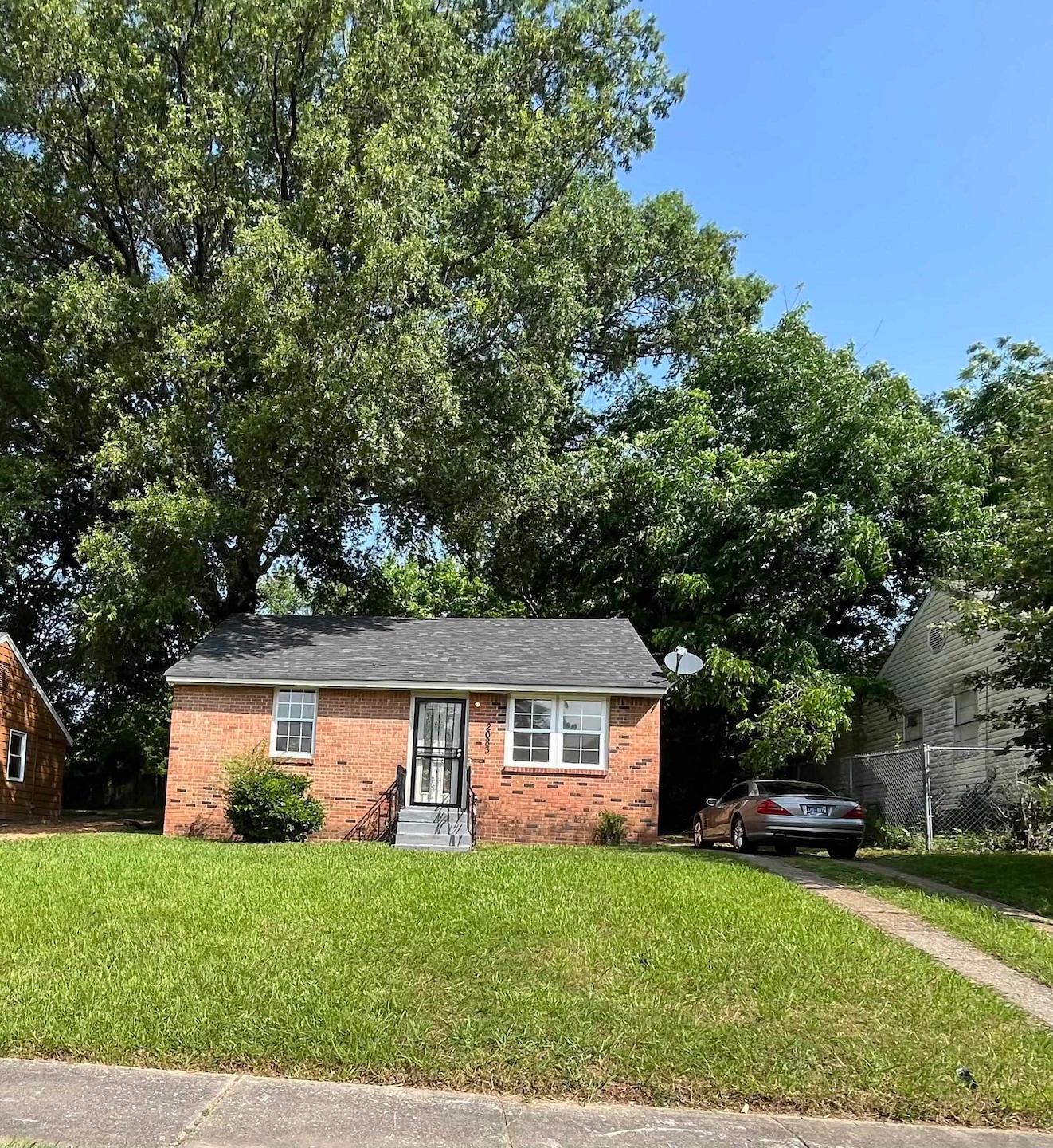 View of front of house with brick siding, a front lawn, and entry steps