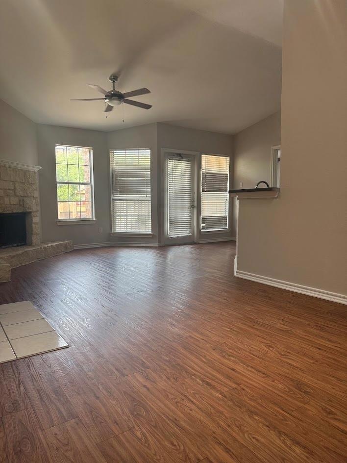 Unfurnished living room with dark wood-style floo