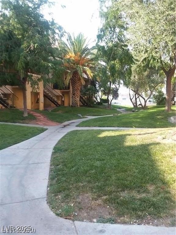 View of community featuring a yard and stairs