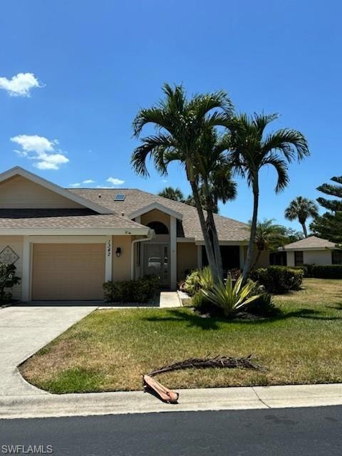 Ranch-style home featuring driveway, roof with shingles, a front yard, a garage, and stucco siding
