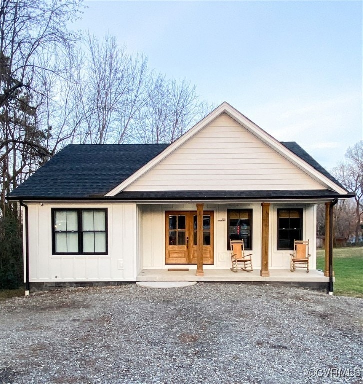 Modern inspired farmhouse with a shingled roof, bo