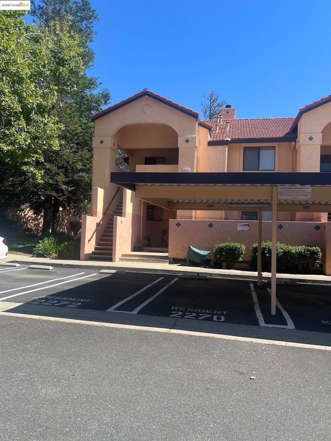 View of property featuring stairs and covered parking
