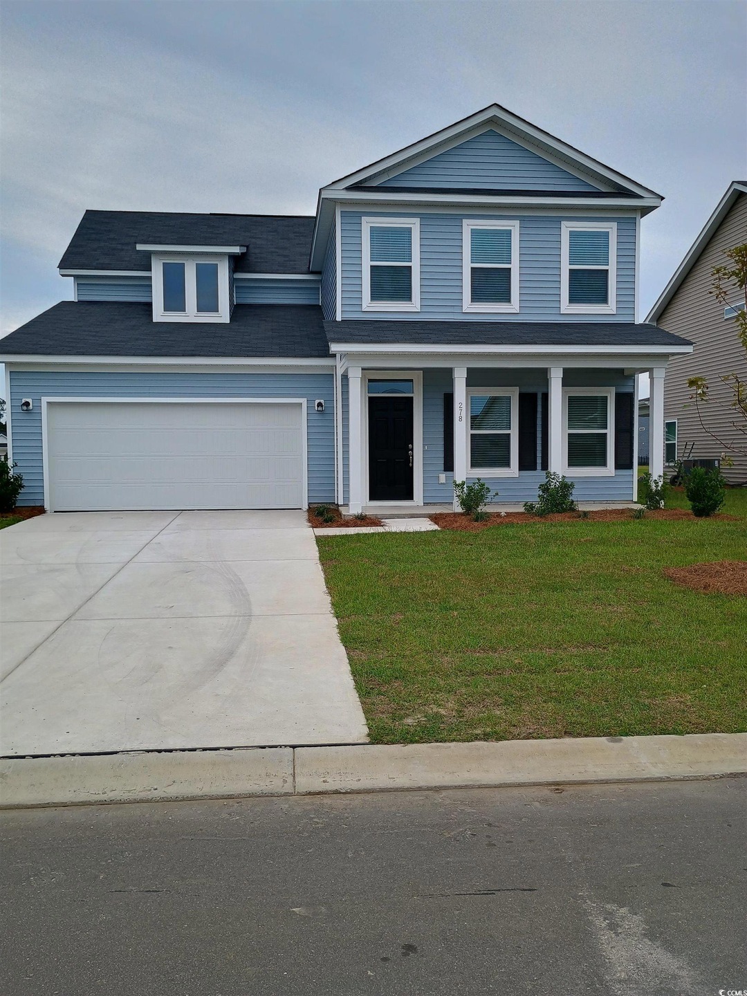 View of front facade with a garage and a front law